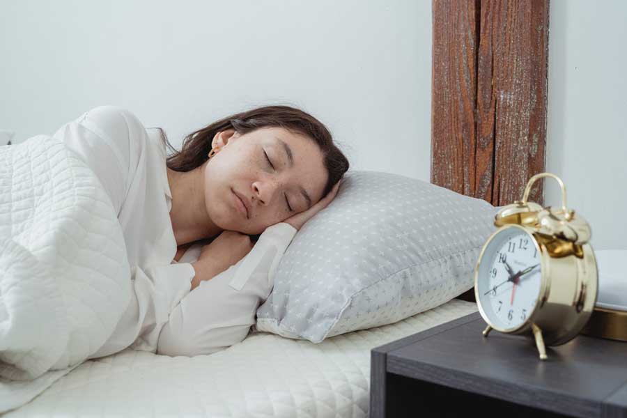 Woman sleeping on large pillow in her bed